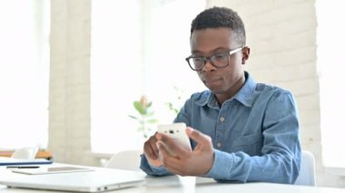 Ofisteki Akıllı Telefondaki Başarıyı Kutlayan Genç Afrikalı Adam 