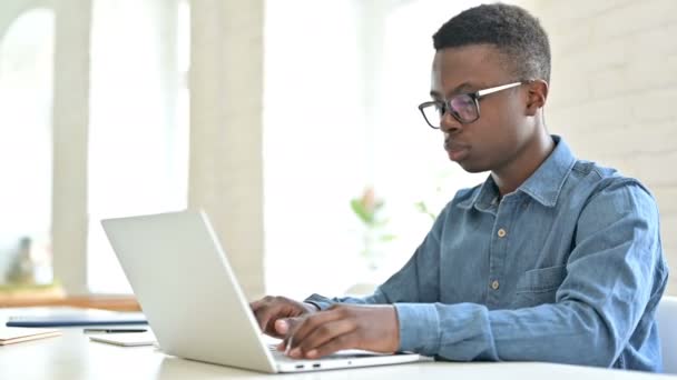 Giovane uomo africano con il computer portatile che punta con il dito alla fotocamera — Video Stock