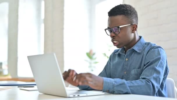 Задоволена молода африканська людина реагує на втрату на лаптопі — стокове відео