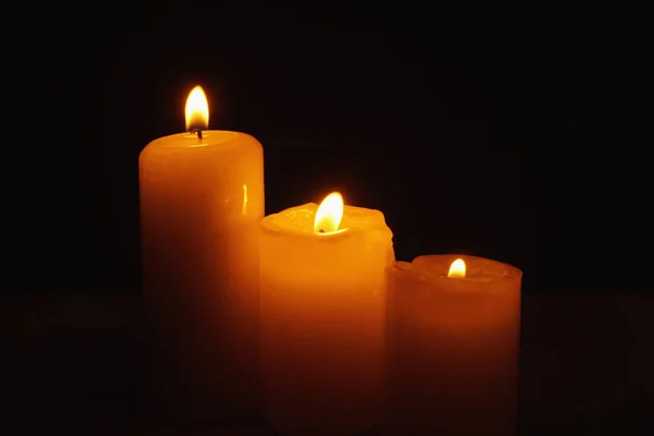 Three burning candles in the darkness — Stock Photo, Image