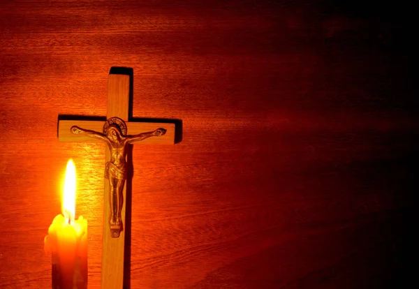 Ogień świecy i krucyfiks w ciemności — Zdjęcie stockowe