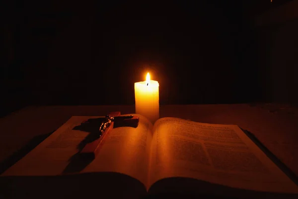 Vela ardente, bíblia e crucifixo na mesa — Fotografia de Stock