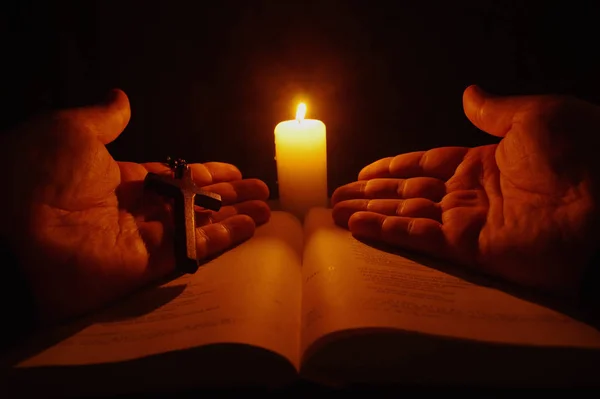 Vela ardiente, Biblia abierta y manos de oración —  Fotos de Stock