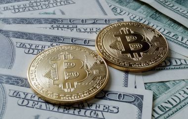 Two symbolic coins of bitcoin on banknotes of one hundred dollar clipart