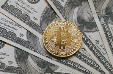 Bitcoin yüz dolarlık banknot üzerinde sembolik sikkeleri.