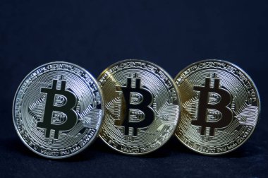 Bitcoin siyah arka plan üzerine üç sikkeleri. 