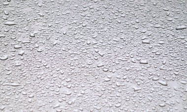 Gri yüzeyde su damlaları.