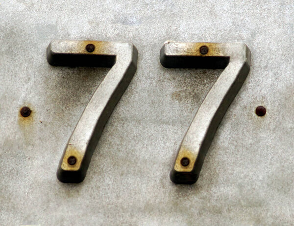 Street number iron sign  with number 77. Lucky number. Seventy seven. 
