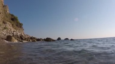 Deniz taşları güçlü dalgaları kırıyor.