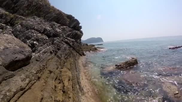 Mar tranquilo, la suave ola golpeando las rocas costeras , — Vídeos de Stock