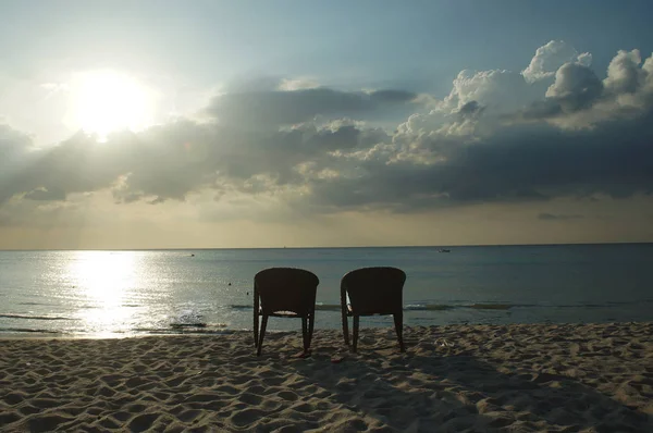 Одинокие стулья на фоне моря — стоковое фото
