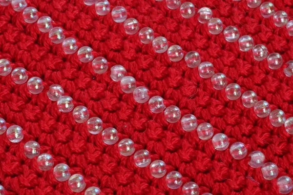 Tecido de malha de cor vermelha com a decoração de contas — Fotografia de Stock