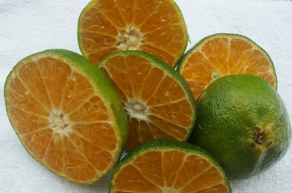 白い背景の上の緑色の肌を持つ赤の柑橘系の果物 — ストック写真