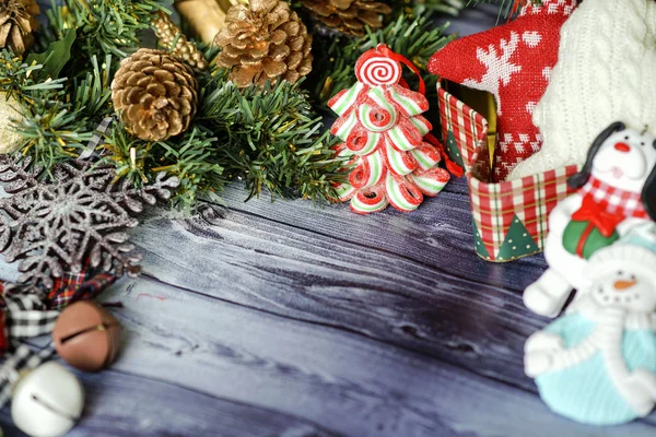 Kerst samenstelling op houten achtergrond rode ballen, geschenken en groene kerstboom tak met kegels, brandende kaars — Stockfoto