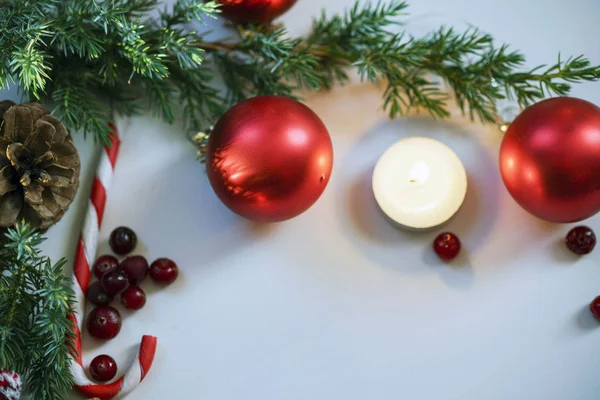 Kerst samenstelling op houten achtergrond met kerstballen en groene tak kerstboom met dennenappels, brandende kaars — Stockfoto