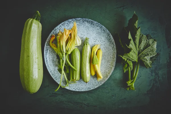 Fresh zucchini and zucchini flowers — Stock Photo