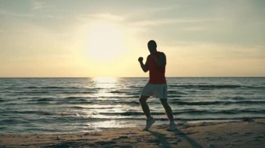 adam siluet boks gün batımında sahilde