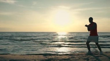 gün batımında sahilde boks adam