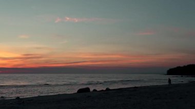 gün batımında sahilde koşan adam