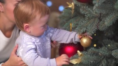 Anne ve çocuğu bir ağacı süsleme