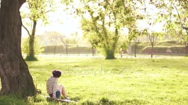 Açık havada ağaç altında oturan güzellik kadın