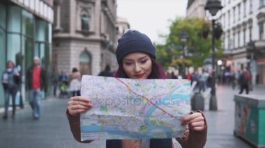 Bir harita ile sokakta yürüyen kadın turist