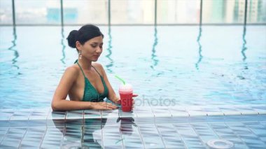 genç güzel seksi kız havuzda kokteyl içme
