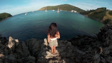 Manzarayı bir kayada duran genç kadın