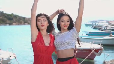 İki mutlu kadın kırmızı elbiseler içinde dans