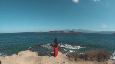 Geri cliff üzerinde deniz infront duran genç kadın