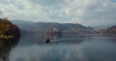 Bir çift bir ahşap tekne bir gölde kürek