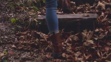 Sonbahar yaprakları üzerinde orman merdivenlerde yürürken ayakları