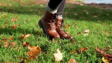 sonbahar yaprakları üzerine yürüyen kadın bacakları