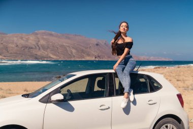 Güzel kız beyaz bir araba üzerinde oturan