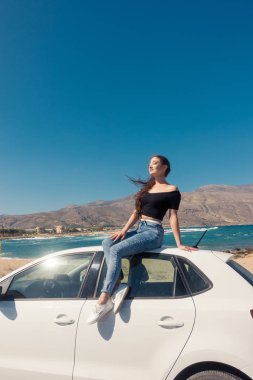 Beyaz arabanın üstüne oturan mutlu genç kız