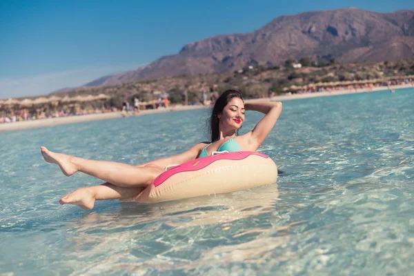Young woman swimming on the inflatable ring