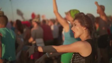 Açık hava rock konserinde çeşitli hayran grupları dans ediyor. Dışarıdaki müzik festivalinde Asyalı kadınlar kapışıyor. Alternatif punk şarkıları dinleyen asi genç anarşistler. Konserde kalabalık alkışlıyor