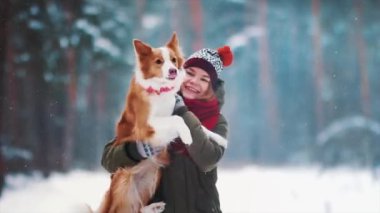 Gülümseyen bayan köpeğiyle boş zaman geçirir. Kış karlı ormanlarda çoban köpeğini kucaklayan kadın portresi. Aşk ve aile kavramı. Arkadaşıyla evcil hayvan severmiş. Şehir dışında tatilin tadını çıkarıyorum.