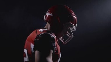 Profesyonel Amerikan futbolcusunun miğferli portresi oyuna ve saldırıya hazır. Üniformalı, kendinden emin ve agresif bir adam. Usa takım oyunu ve ekstrem spor ruhu konsepti.