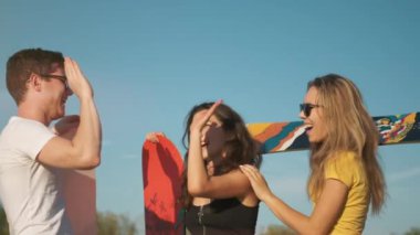 Açık havada yaz. Mutlu gülümseyen insanlar, ellerinde snowboard ile güneşli bir gecede beş kez arka planda bulunuyorlar. Çölde kum kaykayı. Genç arkadaşlar buluşuyor. Tatil, turizm ve ekstrem spor konsepti.