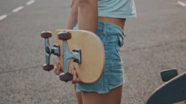 İki genç kız, Avrupa sokaklarında gün ışığında kaykaylı bir kaykayla dışarıda bir şeye gülüp konuşuyorlar. Kızıl Kamera 'da kaykay yapan çok ırklı genç kadınlar.