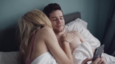 Heteroseksüel çift yatakta sorun yaşıyor. Efsanevi bir adam ve kız arkadaşına olan tutumunu ödemiyor. Evlilik, telefon bağımlılığı, aile, aşk, seks konsepti. Çekimler kırmızı 4k, 10 bit renk