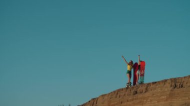 Gün batımında Dubai çölünde iki güzel kız. Yaz tatili, seyahat yaşam tarzı ve turizm. Kum tepelerindeki güzel kadınlar domuz etiyle eğleniyorlar. Açık hava aktiviteleri ve spor konsepti.