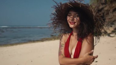 Bali egzotik atmosferi ile seksi görünümlü melez bayan tatilini tropikal adada geçiriyor. Kırmızı elbiseli, tropik plajda parlak makyajlı güzel bir Asyalı kadın. Güzellik moda konsepti ve yaşam tarzı