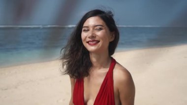 Zaman parmaklarının arasından kum gibi akıyor. Mutlu Asyalı kadın kumdan eller döküyor. Güzellik, seyahat, zaman kavramı. Hasır şapkalı neşeli Asyalı kadın parmaklarının arasındaki kumu temizliyor..