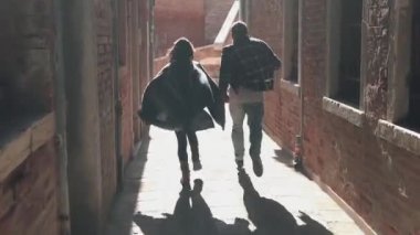 Venedik 'te güneşin doğuşunda koşan romantik melez çift. İtalya 'daki antik kentin dar sokaklarında gezip maceralar arayan mutlu genç aşıklar. Balayı kavramı.