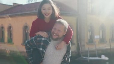 Genç aşık hippi çift uzun bir geçmişi olan güzel bir ülkede eğleniyor. Aşk kavramı. Yakışıklı Avrupalı adam Venedik sokaklarında muhteşem Asyalı kadınını sırtında taşıyor.