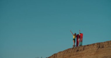 Gün batımında Dubai çölünde iki güzel kız. Yaz tatili, seyahat yaşam tarzı ve turizm. Kum tepelerindeki güzel kadınlar domuz etiyle eğleniyorlar. Açık hava aktiviteleri ve spor konsepti.