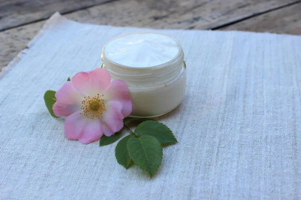 Cosmetische crème met rozenbottel bloem Rechtenvrije Stockafbeeldingen