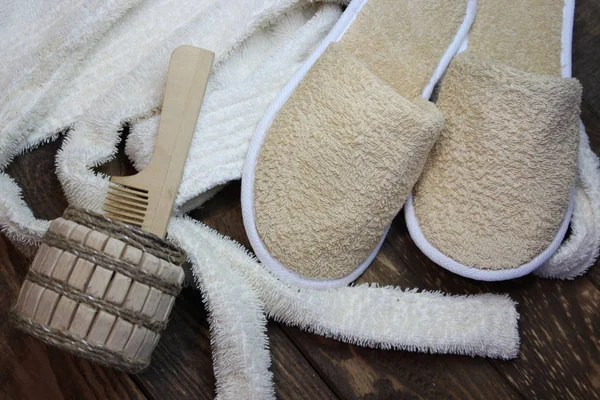 Terry roupão de banho e chinelos de banho com um pente de madeira — Fotografia de Stock